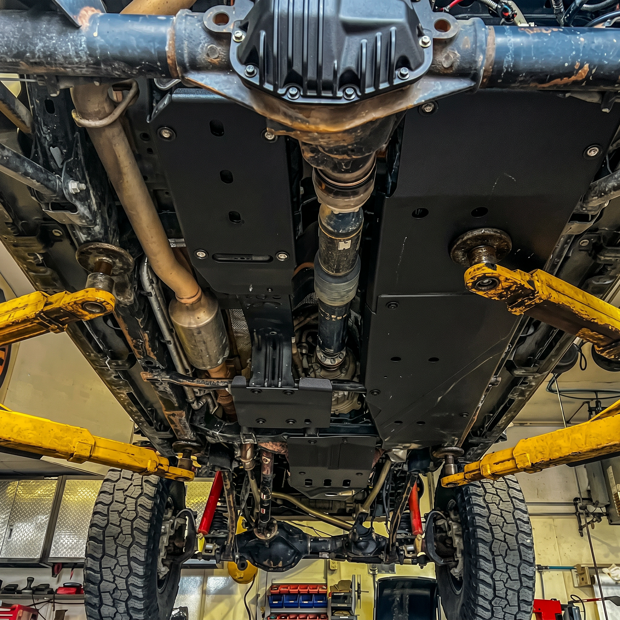 Close-up of a vehicle's undercarriage with visible suspension and exhaust system.