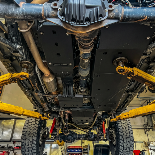 Close-up of a vehicle's undercarriage with visible suspension and exhaust system.
